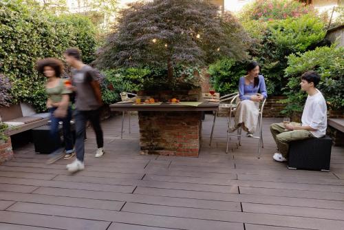 a group of people sitting around a table in a garden at Biocity in Milan