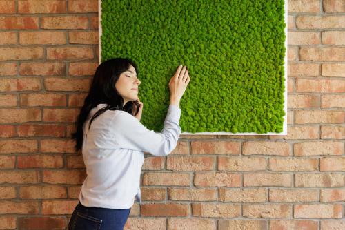 a woman standing next to a brick wall at Biocity in Milan