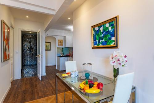 une salle à manger avec une table en verre et un vase de fleurs dans l'établissement LE ROYAL AP4456 by Riviera Holiday Homes, à Nice