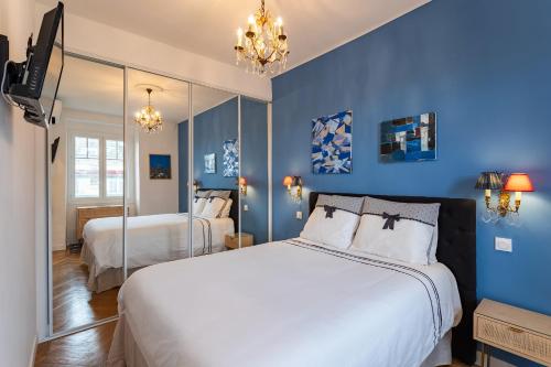 une chambre avec des murs bleus et un grand lit dans l'établissement LE ROYAL AP4456 by Riviera Holiday Homes, à Nice
