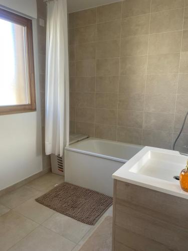 une salle de bain avec une baignoire blanche et un lavabo dans l'établissement Maison tout confort avec jardin à 35 min de Paris, à Arpajon