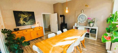a dining room with a wooden table and white chairs at Auszeit auf dem Drachenhof, das Hyggehaus in Plattenburg