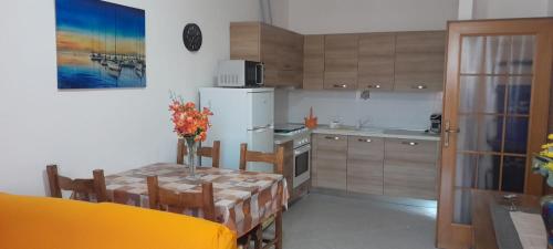 a kitchen with a table and a white refrigerator at Pretty Appartment Beb in Alghero