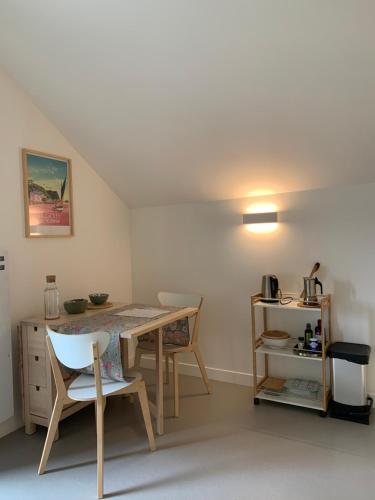 Cette chambre comprend une table, des chaises, une table et une étagère. dans l'établissement Ambiance bois - 2 appartements, à Vannes