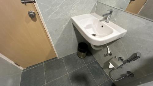 a bathroom with a white sink and a door at Serene Resort Hyderabad in Shamshabad