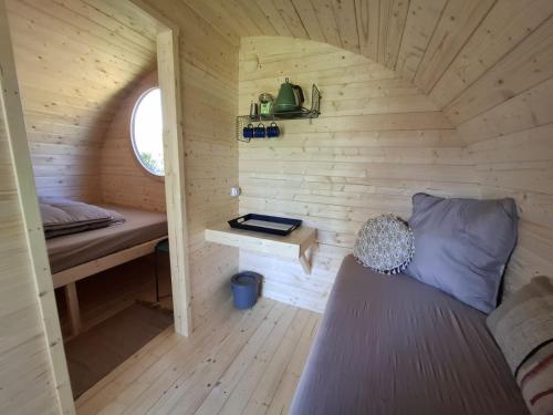 une petite pièce avec un lit et une fenêtre dans l'établissement Le Cabanon du camping 2, à Bannes