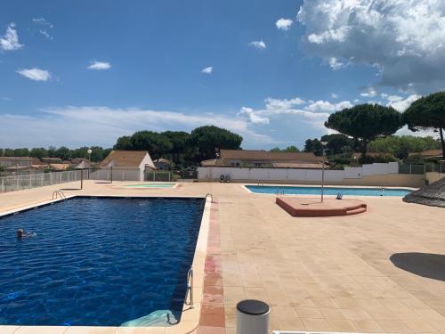 une grande piscine avec de l'eau bleue dans l'établissement Maison 6 personnes climatisée dans résidence avec piscine à 900 M des plages, à Vendres-Plage