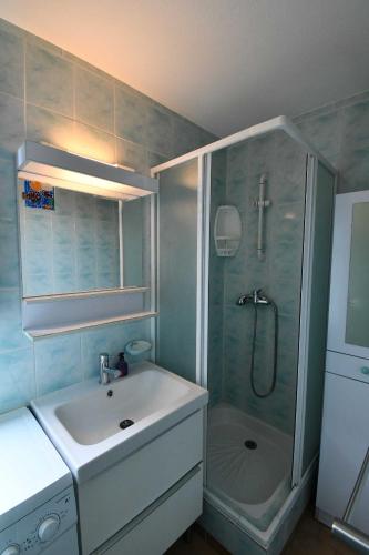 une salle de bain avec un lavabo et une douche dans l'établissement Maison 6 personnes climatisée dans résidence avec piscine à 900 M des plages, à Vendres-Plage