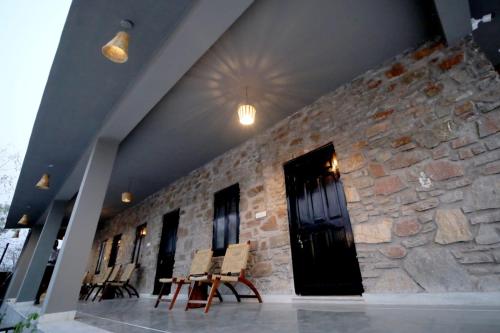 a lobby with chairs and a stone wall at Badi Meadows in Udaipur