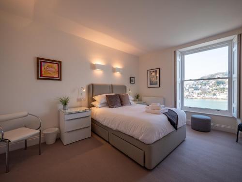 a bedroom with a bed and a large window at Riverside Apartment with Stunning Views & Patio in Dartmouth