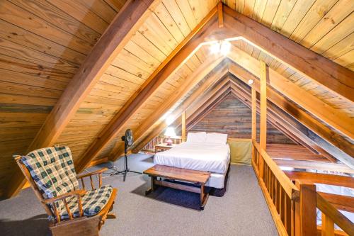 a bedroom with a bed and a chair in a attic at Game Room and Decks Family Cabin in Springville! in Springville