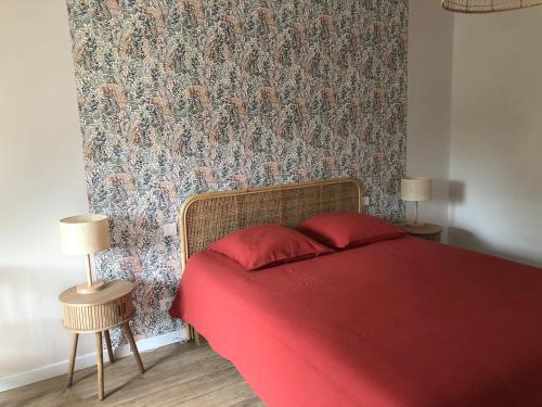 a bedroom with a red bed with a floral wallpaper at La verrerie in Hardinghen