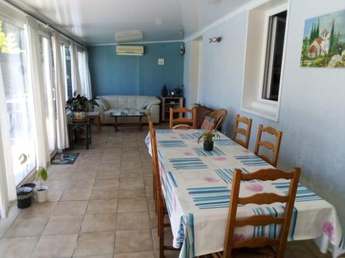 une salle à manger avec une table, des chaises et un canapé dans l'établissement SunHouse, à Aigues-Vives
