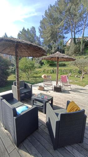 une terrasse avec des canapés, des tables et des parasols dans l'établissement Villa FAMILIALE au CALME avec grand JARDIN, à Peypin