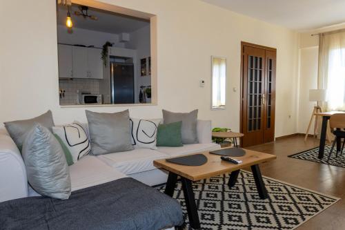 a living room with a white couch and a table at THETIS Luxury House in Nikiti
