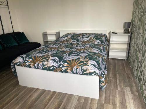 une chambre avec un lit avec un couvre-lit fleuri dans l'établissement Nova nuit, à Bout dʼAmont