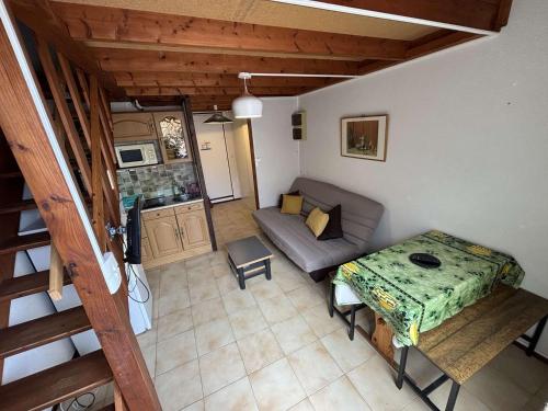 un petit salon avec un canapé et une table dans l'établissement Studio mezzanine climatisé proche plage, 4 couchages, balcon, TV et cuisine équipée - FR-1-229C-181, à Port-la-Nouvelle