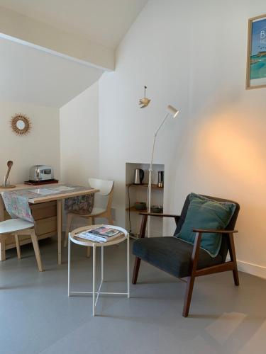un salon avec une table et une chaise dans l'établissement Ambiance bois - 2 appartements, à Vannes