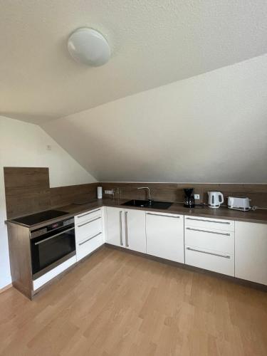 a kitchen with white cabinets and a stove top oven at Eifelbrise in Simmerath