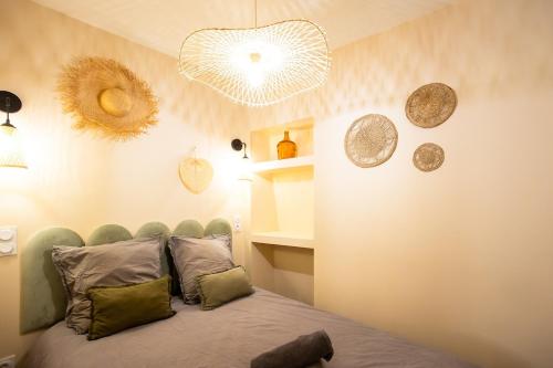 - une chambre avec un lit et quelques assiettes murales dans l'établissement Cosy & Chill Appartements - Au cœur du village de Cotignac, en Provence, à Cotignac