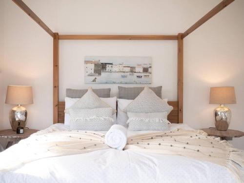 a bedroom with a large white bed with two lamps at Large Riverside Retreat With Panoramic Dart Views in Dartmouth