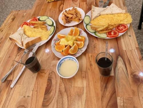 a wooden table with plates of food on it at Khách Sạn Tiến Loan in Hòa Bình