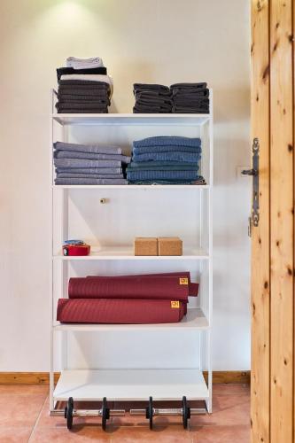 une étagère blanche avec des vêtements pliés dans l'établissement Gîte 5 chambres entre Reims et Epernay - Le Tilleul - Gîtes Au Beau Sarrazin, à Fontaine-sur-Ay