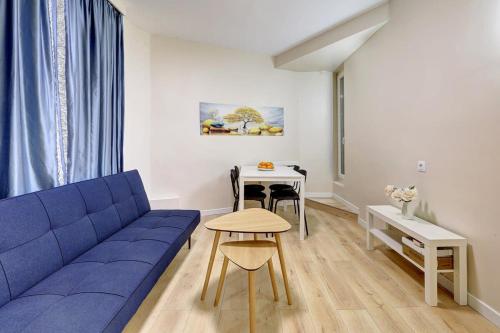 un salon avec un canapé bleu et une table dans l'établissement Evasion Parisienne Tranquillite au Marais, à Paris