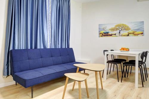 un salon avec un canapé bleu et une table dans l'établissement Evasion Parisienne Tranquillite au Marais, à Paris