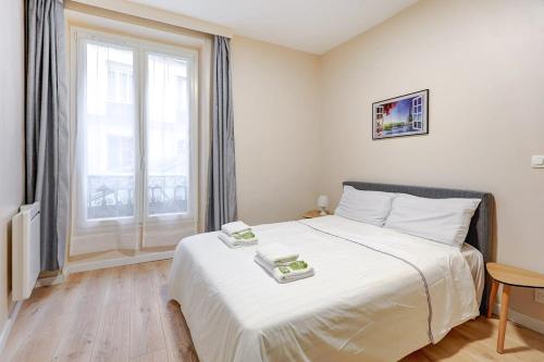 une chambre avec un lit et une grande fenêtre dans l'établissement Evasion Parisienne Tranquillite au Marais, à Paris