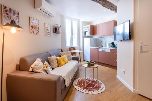 un salon avec un canapé et une cuisine dans l'établissement Cosy & Chill Appartements - Au cœur du village de Cotignac, en Provence, à Cotignac