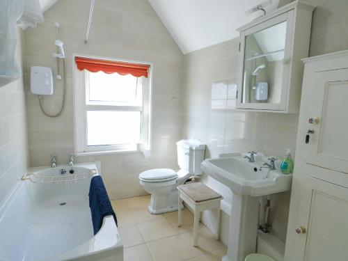 a white bathroom with a sink and a toilet at The Harbour in Rhosneigr