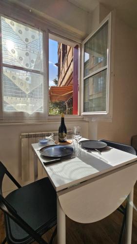 une table blanche avec une chaise et deux fenêtres dans l'établissement Nid douillet dans le village de Marcillac-Vallon, à Marcillac-Vallon
