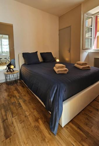 a bedroom with a large bed with towels on it at Nid douillet dans le village de Marcillac-Vallon in Marcillac-Vallon