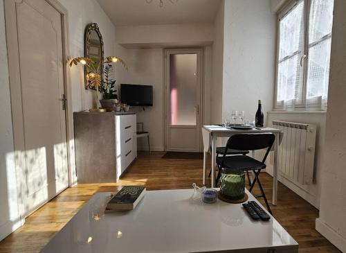 a living room with a table and a chair in it at Nid douillet dans le village de Marcillac-Vallon in Marcillac-Vallon