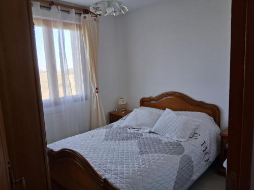 - une chambre avec un lit doté d'une fenêtre et d'un couvre-lit blanc dans l'établissement les sables, à La Celle-sous-Gouzon