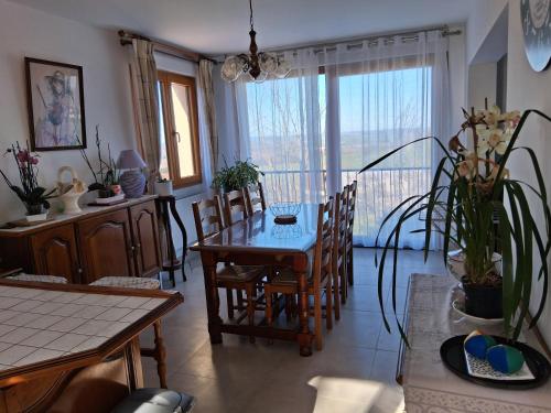 une salle à manger avec une table et des chaises et une fenêtre dans l'établissement les sables, à La Celle-sous-Gouzon