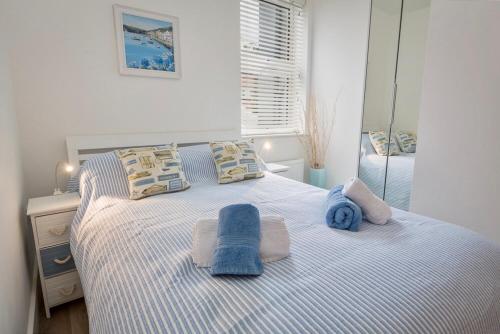 ダートマスにあるCharming Apartment With Garden & Parkingの青いタオルが敷かれたベッドのある寝室