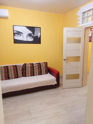 a living room with a couch in a yellow wall at Автовокзал вул Колонтаївська in Odesa