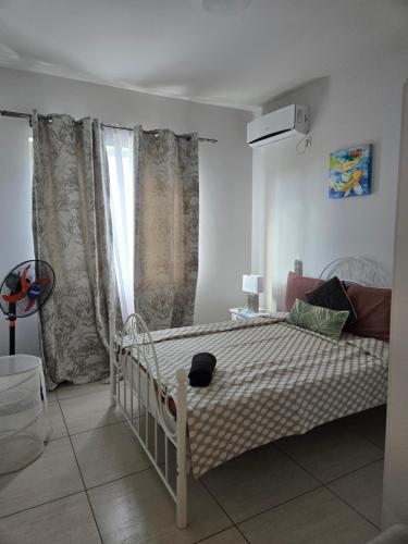 a bedroom with a white bed and a window at Modern and cosy condo: Westwood Apartments in Flic-en-Flac