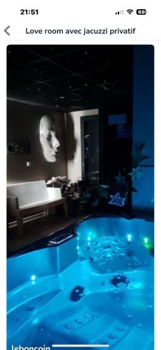 Cette chambre dispose d'une grande piscine bleue avec un banc. dans l'établissement Suite romantique Au cœur du Spa avec jacuzzi et sauna privatif proche de Toulouse, à Auterive
