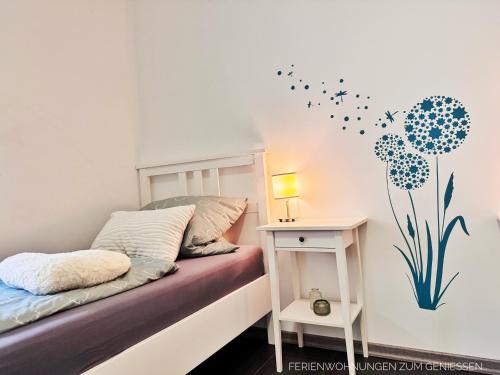 a bedroom with a bed and a table with a lamp at Ferienhaus Nordkönig mit Sauna und Whirlpool in Langen