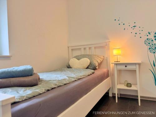 a room with a bed with a heart pillow on it at Ferienhaus Nordkönig mit Sauna und Whirlpool in Langen