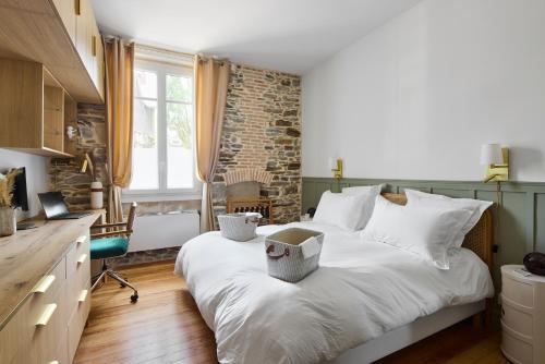 une chambre avec un grand lit blanc et un bureau dans l'établissement Le Jardin Secret - 2 chambres & Parking Offert, à Nantes