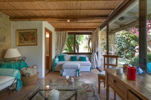 a living room with a couch and a table at Cala di Volpe - Villa con vista mare e golf club in Abbiadori