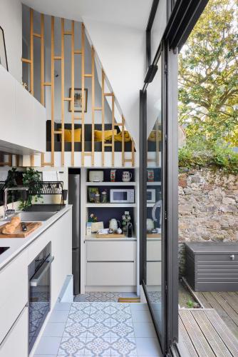 une cuisine avec des placards blancs et un escalier dans l'établissement Le Jardin Secret - 2 chambres & Parking Offert, à Nantes