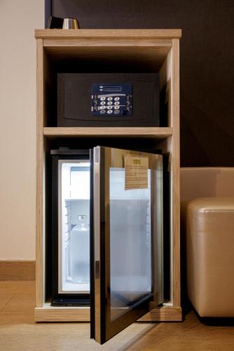 a small refrigerator with a clock on top of it at Biocity in Milan