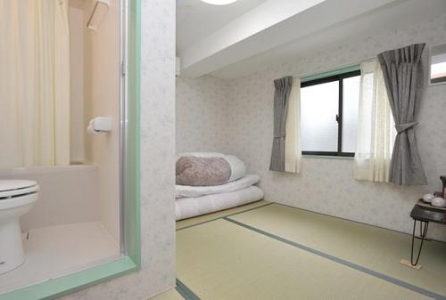 baño con lavabo y aseo y ventana en BJ family inn en Kyoto