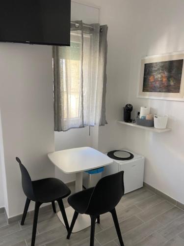 a kitchen with two chairs and a white table at La Giara in Alghero