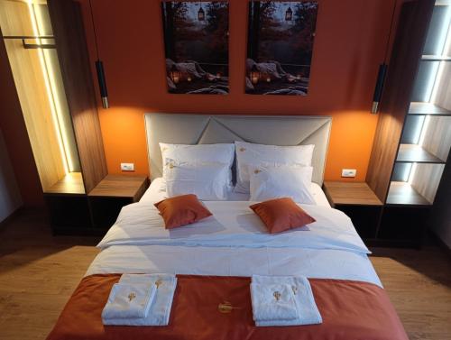 a bedroom with a large white bed with two pillows at Apartmani Leburic in Prnjavor